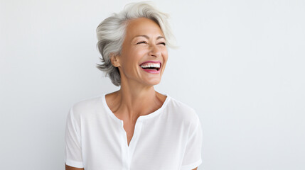 Beautiful gorgeous mid aged mature woman looking at camera isolated on white. Mature old lady close up portrait. Healthy face skin care beauty, middle age skincare cosmetics, cosmetology concept - obrazy, fototapety, plakaty