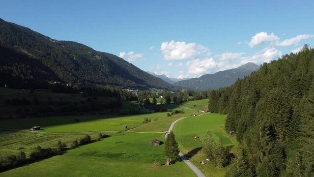 Mountains in Austria with green forests and meadows at dusk in 4k