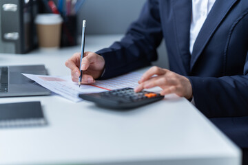 Asian businessman using laptop computer and smartphone contact business search information on desk...