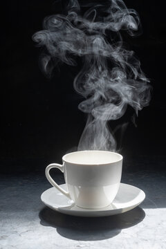 Steaming coffee cup on dark background