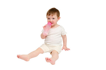 Happy baby drinks milk from bottle on studio, isolated on white background. Resting child eats formula, isolated on white background. Kid about two years old (one year nine months)