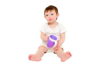 Happy baby drinks water from cup on studio, isolated on white background. Resting child with cup...
