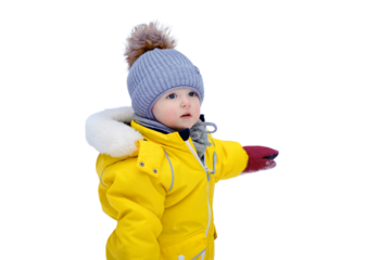 Happy toddler baby is playing in a yellow snowsuit, isolated on white background. Child boy in warm clothes walks in snowy winter park, isolated on white background. Kid aged one year six months