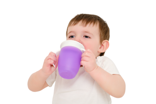 Happy baby drinks water from cup on studio, isolated on white background. Resting child with cup juice in hands, isolated on white background. Kid about two years old (one year nine months)
