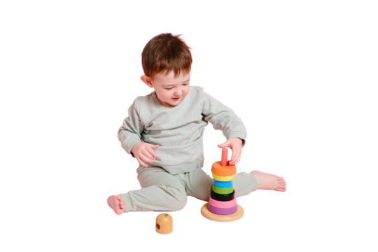 Happy toddler baby plays with a pyramid on a studio, isolated on white background. Child boy puts wooden rings on a toy pyramid, isolated on white background. Kid age one year eight months