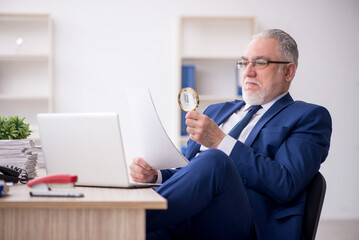 Old male employee working in the office