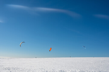 Kitesurfing in the snow with a blue sky