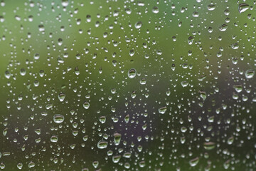 Lots of raindrops on the window. Rainy season concept. Climate change. Wet in rain. Focus on water droplets on window.