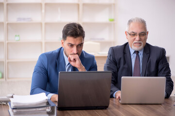 Two male employees working in the office