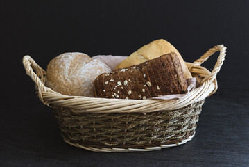 Three different types of bread in a wicker basket.