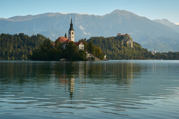 Landscape of Lake Bled on an autumn morning with the famous Church on the Island and the Alps in...