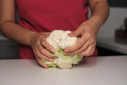 Delicate Hands Break Apart Colorful Cauliflower On A Modern Kitchen Countertop. Discover The Joy Of Healthy Eating Amidst A Hectic Life.