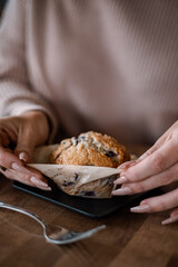 Woman in coffee shop with blueberry muffin