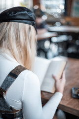 Looking over shoulder of woman reading a book in a coffee shop
