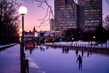 People skating on Rideau Canal Skateway, dusk, winter, Ottawa, Ontario, Canada