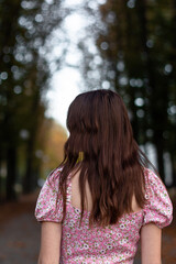 girl walking in the autumn park, photo from the back