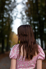 girl walking in the autumn park, photo from the back