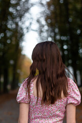 girl walking in the autumn park, photo from the back