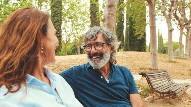 Loving couple talking while sitting outside in the park in autumn