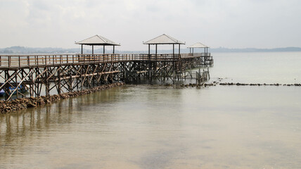 Wooden bridge dock or pier or boardwalk jetty for ship to dock at the shore.