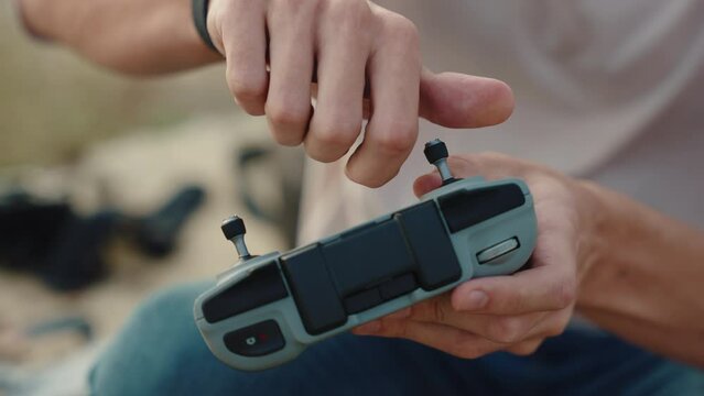 Young male cameraman screws a joystick into a drone controller. close-up shot. Day, outdoor shot. 