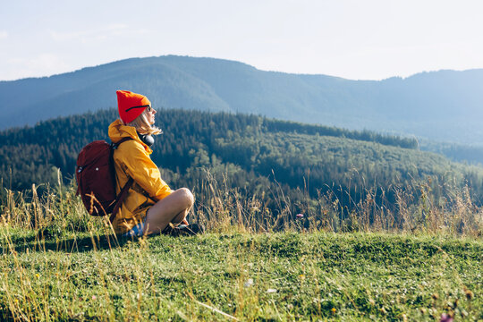 Young hiking woman enjoys a break look at the mountain. Active vacations concept image
