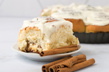 Fresh Cinnabon rolls with cinnamon and white cheese cream, close up.