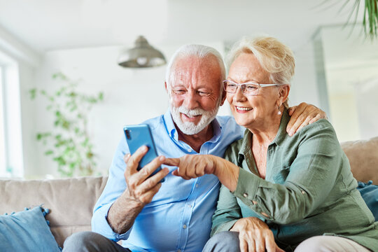 woman man senior retirement couple mobile phone phone home communication elderly adult happy smiling old mobile family husband mature wife