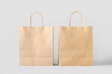 Kraft paper bag with handles, blank mockup isolated on a grey background.