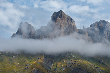 Russia. The Elbrus region. The high mountain peaks of the North Caucasus are surrounded by morning misty clouds hovering at different levels of inaccessible rocks.