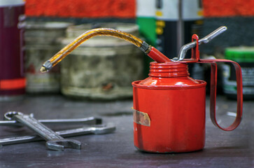 Vemos la imagen de una aceitera lubricadora , sobre el banco de trabajo de un taller mecánico , o...