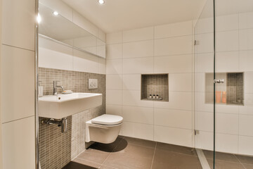 a bathroom with a toilet, sink and shower stall in the same room on the left side of the photo