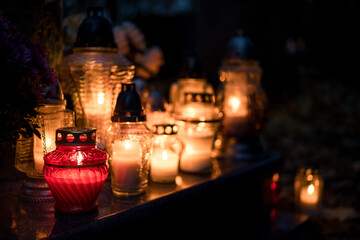 Lit grave candles on a tombstone on a November evening with soft warm candlelight — Poland,...