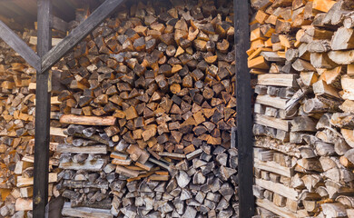 Shot of the wooden logs stacked in the storage. Background