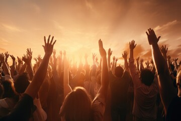 A picture of a group of people raising their hands in the air. Perfect for illustrating unity,...