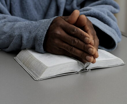 man praying to God with the bible on black background with people stock image stock photo	