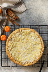 Thanksgiving dessert. Fall traditional pie pumpkin with crumble and pecan on a gray stone background. View from above. Copy space.