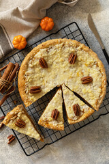 Fall traditional pie pumpkin with crumble and pecan on a gray stone background. Thanksgiving dessert. View from above.