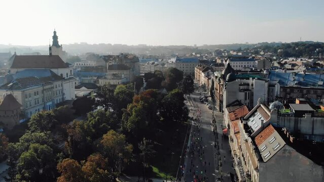 Athletes Running a Marathon in a City on Road. Shot from Drone. Start of Competitions. Scenery of a City. Architecture
