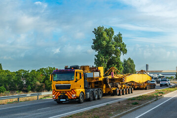 Transportation of oversized cargo occupying both lanes of the road due to its enormous length,...