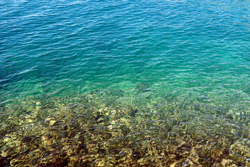 Transparent shallow sea with pebbles under the surface