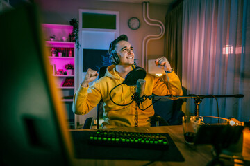 Young man male gamer playing computer game streaming video winning