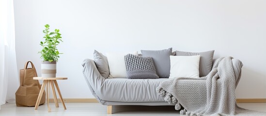 Grey knit blanket pillows and bright interior with couch in front With copyspace for text