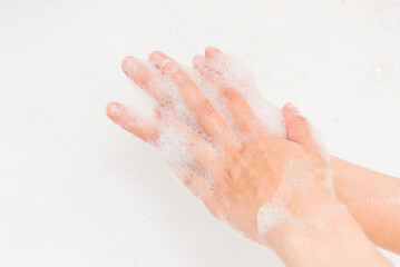 Foam soap on woman hand close up view. Skincare washing hand. Bath relaxing time.