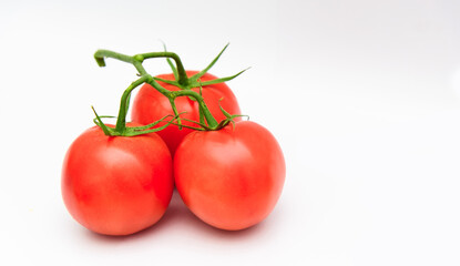 Fresh ripe red tomatoes bunched on a white background.