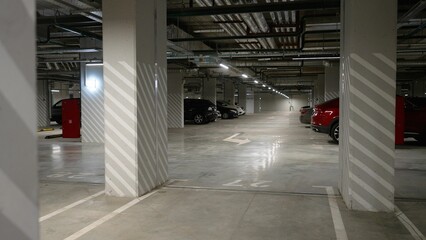 Underground parking under a modern apartment in a residential complex, parked cars, no one, plenty...
