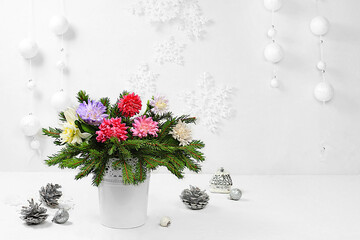 Empty table with a bouquet of live Christmas trees in a vase, with chrysanthemum flowers and homemade decorations on an elegant festive background. Christmas and New Year eco layout for design 