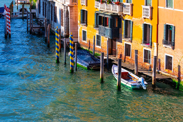 Fototapeta na wymiar Boats and old harbor on water canal in Venice Italy
