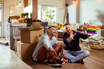 Young male gay couple discussing future plans for their new apartment after moving in