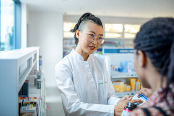 Young pharmacist consulting a African American woman about medication at the pharmacy
